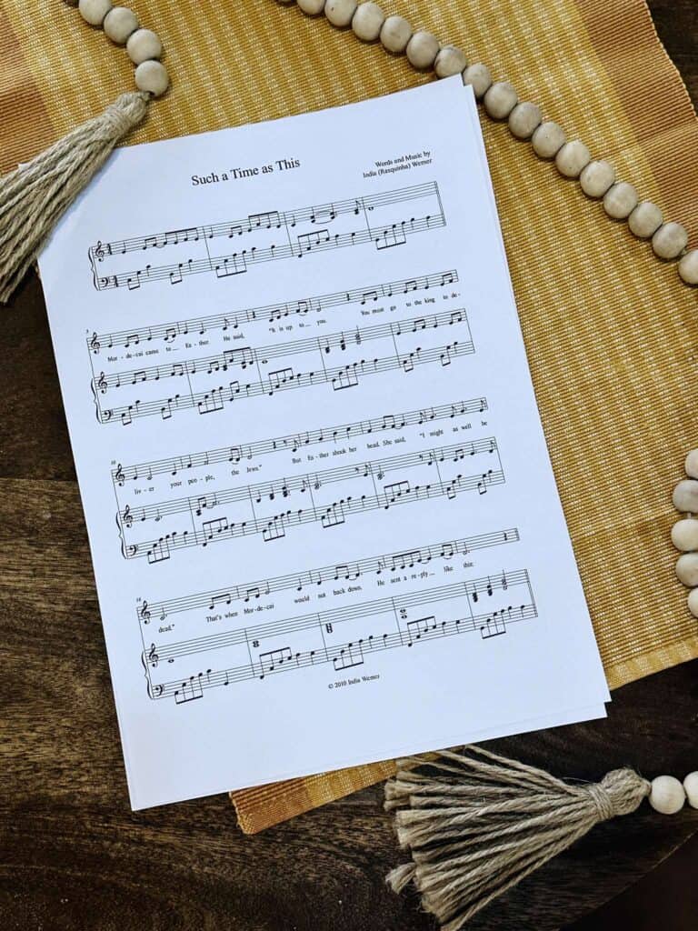 Sheet music to "For Such A Time As This" laying on a wooden table with a yellow placemat.